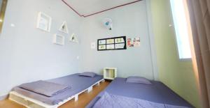 two twin beds in a room with a window at Avocado house in Quy Nhon