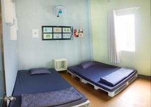 two beds in a room with a window at Avocado house in Quy Nhon