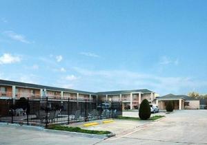 a building with a fence in a parking lot at Nites Inn in Killeen