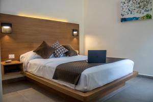 a bedroom with a bed with a laptop on it at Viento Suites Cancún in Cancún +99 photos