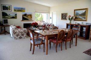 a living room with a wooden table and chairs at L'abri Bed and Breakfast in Akaroa