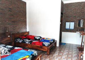1 dormitorio con 2 camas y pared de ladrillo en Ragha Homestay, en Batukaras
