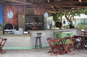 ein Restaurant mit Tischen und Stühlen vor einer Theke in der Unterkunft Ancorar Flat 4203 in Porto De Galinhas
