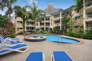 a beach with a pool, chairs, and tables at Surfers Beach Holiday Apartments in Gold Coast