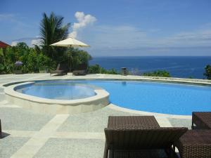 una piscina con due sedie e un ombrellone di Golo Hilltop Hotel a Labuan Bajo