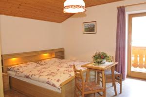 sypialnia z łóżkiem, stołem i krzesłami w obiekcie Fiziderhof w mieście Castelrotto