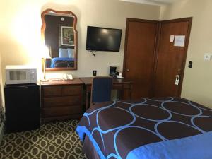 a hotel room with a bed and a desk and a mirror at Budget Inn Marinette in Marinette
