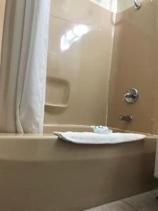 La salle de bains est pourvue d'une baignoire et d'une serviette blanche. dans l'établissement Budget Inn Marinette, à Marinette