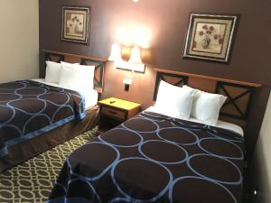 pokój hotelowy z 2 łóżkami i stołem w obiekcie Budget Inn Marinette w mieście Marinette