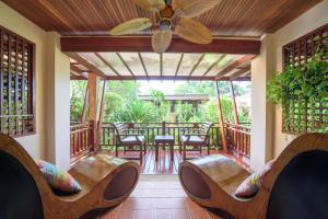 - une terrasse couverte avec des chaises et un ventilateur de plafond dans l'établissement Samui Jasmine Resort - SHA Plus, à Lamai