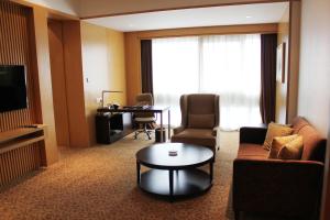 a living room with a couch and a table in a hotel room at Holiday Inn Shijiazhuang Central by IHG in Shijiazhuang +73 photos