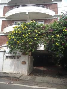 uma árvore em frente a uma garagem com flores em Pleasant Boulevard MG road em Bangalore