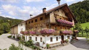 una casa con flores a un lado. en Oberhaslachhof en Reith im Alpbachtal