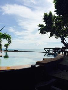 una piscina con el océano al fondo en Petit Suncliff Resort, en Haad Rin