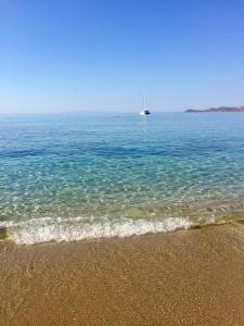 łódź w oceanie z piaszczystą plażą w obiekcie Seafront w mieście Karistos +2 zdjęcia