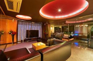 salon ze skórzanymi kanapami i telewizorem w obiekcie HOTEL LOVE w mieście Nagoja