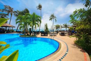 uma piscina com palmeiras e o oceano ao fundo em Rummana Boutique Resort - SHA Plus em Lamai