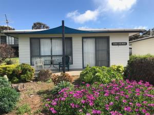 a house with pink flowers in front of it at Wintersun Holiday Cottages in Emu Bay