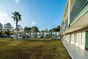 una vista exterior de un edificio con un patio de césped en Days Inn by Wyndham Richmond Hill/Savannah, en Richmond Hill