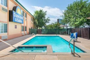 a swimming pool in front of a building at Days Inn & Suites by Wyndham Wichita in Wichita