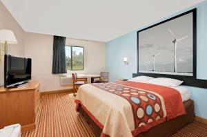 Super 8 by Wyndham Rock Port MO في Rock Port: غرفة فندقية بسرير وتلفزيون بشاشة مسطحة