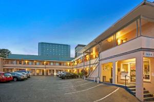 un edificio con coches estacionados en un estacionamiento en Travelodge by Wyndham Everett City Center, en Everett