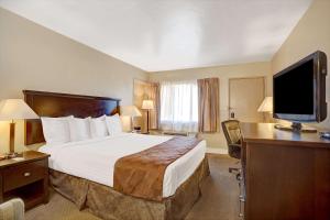 a hotel room with a bed and a flat screen tv at Travelodge by Wyndham Everett City Center in Everett