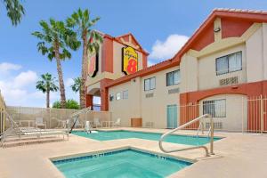 una piscina frente a un hotel con palmeras en Super 8 by Wyndham Tucson/Grant Road Area AZ en Tucson