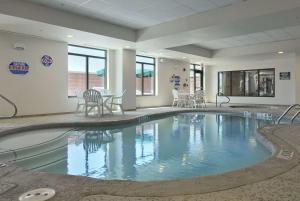 einen großen Pool mit Stühlen und einem Tisch in der Unterkunft Wingate By Wyndham Frisco in Frisco