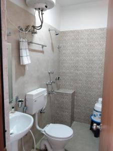 a bathroom with a toilet and a sink at Hotel Ninamma in Gangtok