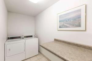 a laundry room with a washing machine and a painting at Days Inn by Wyndham Atlantic in Atlantic