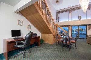 an office with a desk with a computer and a staircase at Travelodge by Wyndham Spearfish in Spearfish