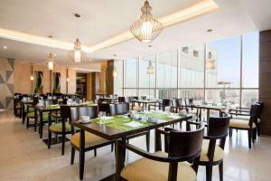a restaurant with tables and chairs and large windows at Wyndham Garden Manama in Manama +90 photos
