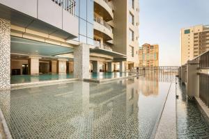 a large building with a large pool of water in front of it at Wyndham Garden Manama in Manama