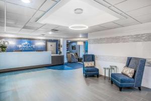 a waiting room with two chairs and a counter at Wingate by Wyndham Louisville Airport Expo Center in Louisville +61 photos