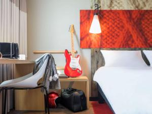 
a bedroom with a bed, desk and lamp at Ibis Hotel Köln Am Dom in Cologne
