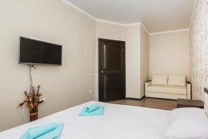 a bedroom with a bed and a tv on the wall at Apartments of PANORAMA Krasnodar in Krasnodar