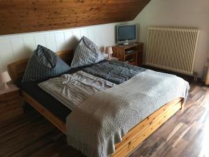 a bedroom with a bed and a tv on a wooden floor at Wagnermoosgut in Bad Ischl