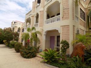 a building with a dog statue in front of it at Jacyjoka Apartments Nyali in Mombasa
