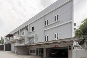 un grand bâtiment blanc avec un garage dans l'établissement RedDoorz near Siloam Hospital Palembang, à Palembang