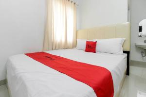 sypialnia z dużym łóżkiem i czerwonym kocem w obiekcie RedDoorz near Siloam Hospital Palembang w mieście Palembang