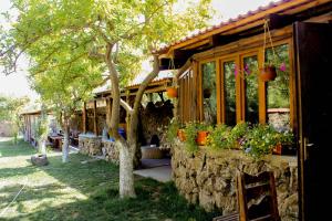 una casa con un muro di pietra e alcune piante di Garni HinYard a Garni