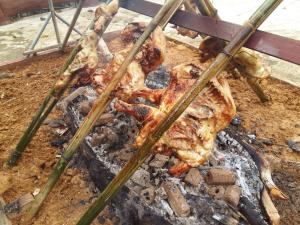 a group of chickens cooking on a grill at Rock and Tree House Resort in Khao Sok