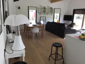 a living room with a table and a white lamp at Maison Fleurie in Uhart-Cize