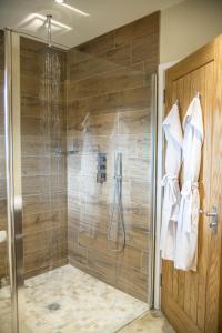 a bathroom with a shower with a glass door at The Three Chimneys Country Pub in Biddenden