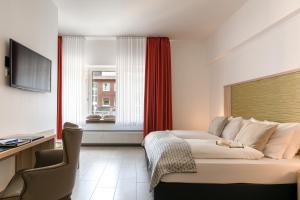 a hotel room with a couch and a window at Hotel Europa in Münster