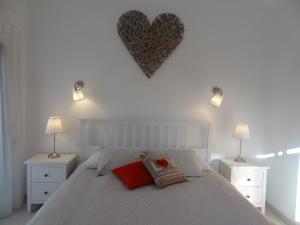 a bedroom with a white bed with a heart on the wall at Sol y Luna Room & Suite Lanzarote Holidays - Heated pool! in Playa Blanca