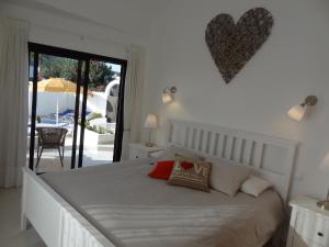 ein Schlafzimmer mit einem weißen Bett mit einem Herz an der Wand in der Unterkunft Sol y Luna Room & Suite Lanzarote Holidays - Heated pool! in Playa Blanca + 15 Fotos