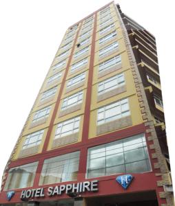 wysoki budynek z znakiem szafirowym hotelu w obiekcie Hotel Sapphire w mieście Dar es Salaam