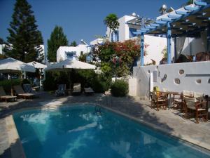 a swimming pool with chairs and tables and umbrellas at Panorama Paros in Parikia